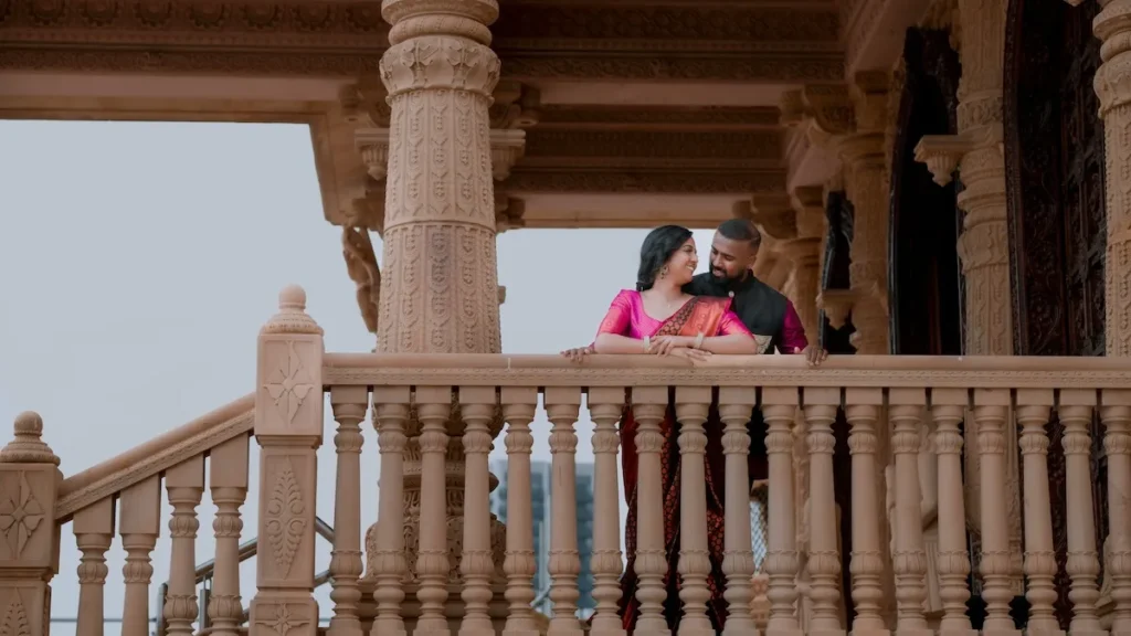 A couple stands together near a staircase