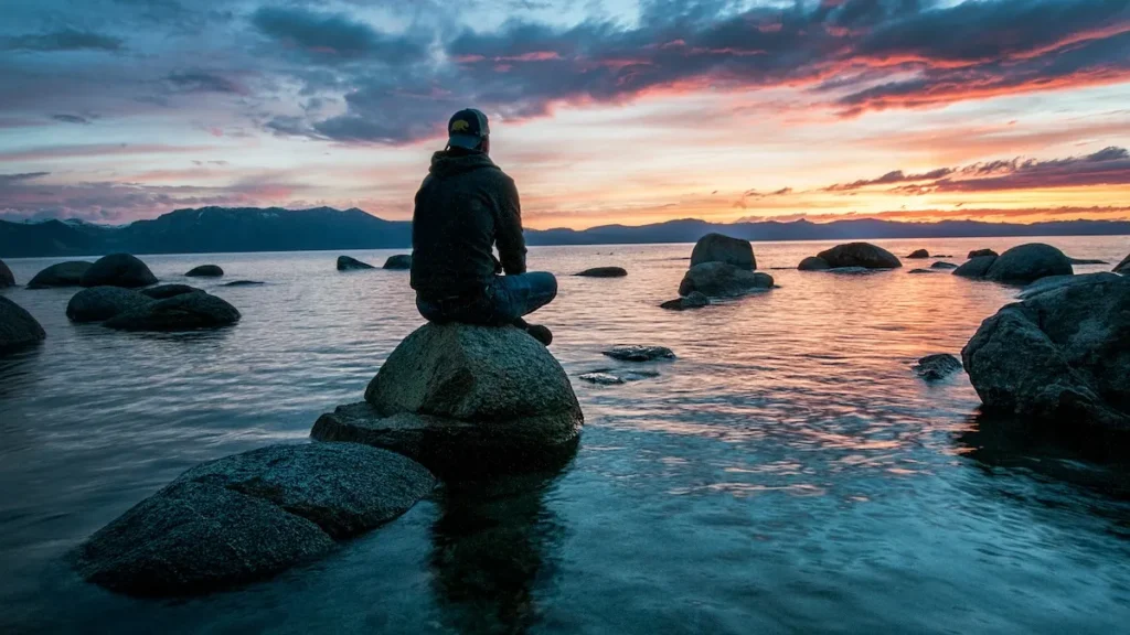 Teen sitting on a rock.